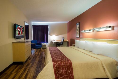 Habitación de hotel con cama grande y escritorio. en Red Roof Inn & Suites Philadelphia - Bellmawr, en Bellmawr