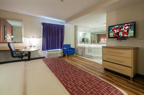 a hotel room with a television and a bathroom at Red Roof Inn & Suites Philadelphia - Bellmawr in Bellmawr