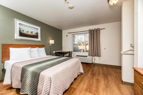 a hotel room with a bed and a window at HomeTowne Studios by Red Roof Fresno - West in Fresno