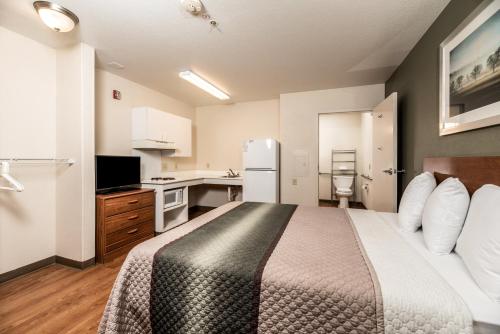 a hotel room with a bed and a kitchen at HomeTowne Studios by Red Roof Fresno - West in Fresno