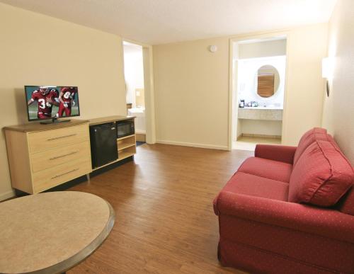 a living room with a red couch and a table at Red Roof Inn Somerset, KY in Somerset