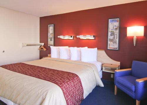 a hotel room with a large bed and a blue chair at Red Roof Inn Somerset, KY in Somerset