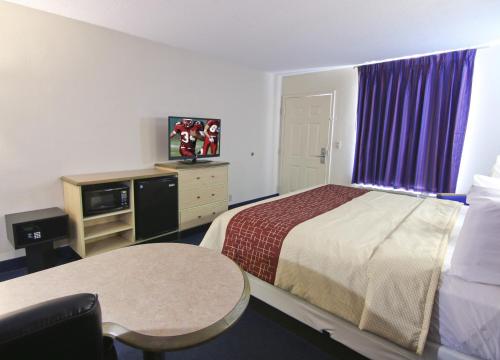 a small hotel room with a bed and a table at Red Roof Inn Somerset, KY in Somerset