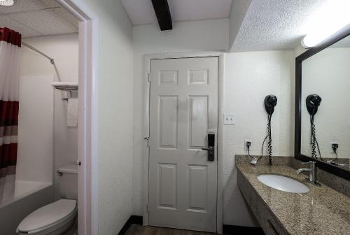 a bathroom with a toilet and a sink and a mirror at Red Roof Inn Lancaster Strasburg in Lancaster