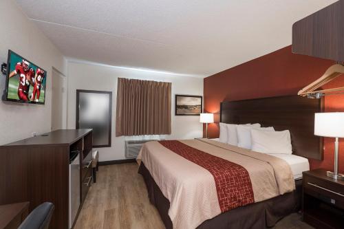 a hotel room with a bed and a desk at Red Roof Inn Lancaster Strasburg in Lancaster