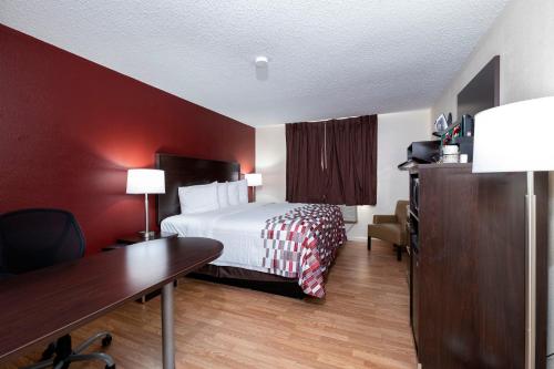 a hotel room with a bed and a desk and a desk at Red Roof Inn Norfolk - Portsmouth in Portsmouth