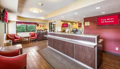 a restaurant with a bar with red chairs at Red Roof Inn Detroit - Plymouth/Canton in Plymouth