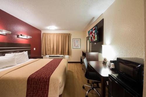 una camera d'albergo con letto e scrivania di Red Roof Inn Houston Brookhollow a Houston