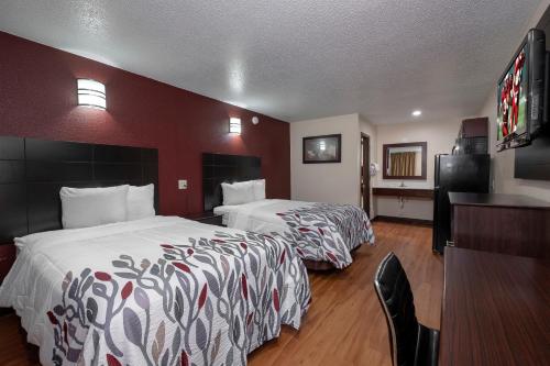 Habitación de hotel con 2 camas y escritorio en Red Roof Inn Morgan City, en Morgan City
