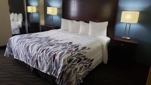 a large bed in a hotel room with two lamps at Red Roof Inn Port Allen in Port Allen