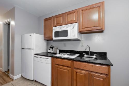 a kitchen with a white refrigerator and a microwave at Red Roof Inn & Suites Wilson in Wilson