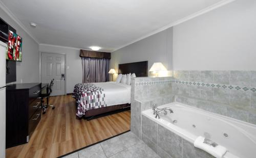 ein Hotelzimmer mit einem Bett und einer Badewanne in der Unterkunft Red Roof Inn Arlington - Entertainment District in Arlington