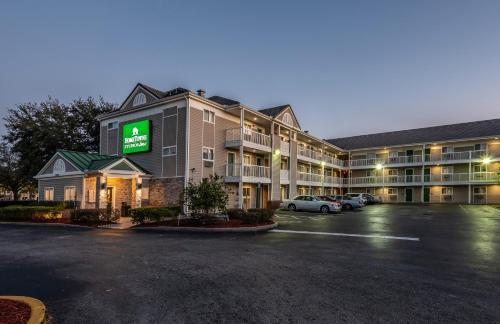 a rendering of a hotel with a parking lot at HomeTowne Studios by Red Roof Orlando South in Orlando