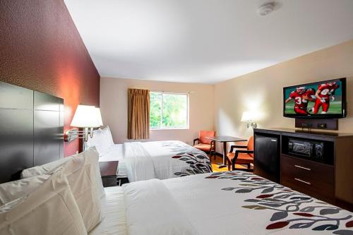 Red Roof Inn San Marcos في سان ماركوس: غرفة فندقية بسريرين وتلفزيون بشاشة مسطحة