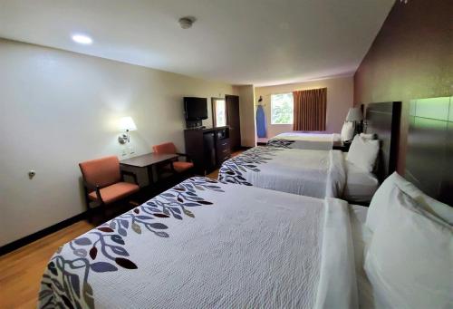 a hotel room with two beds and a desk at Red Roof Inn San Marcos in San Marcos