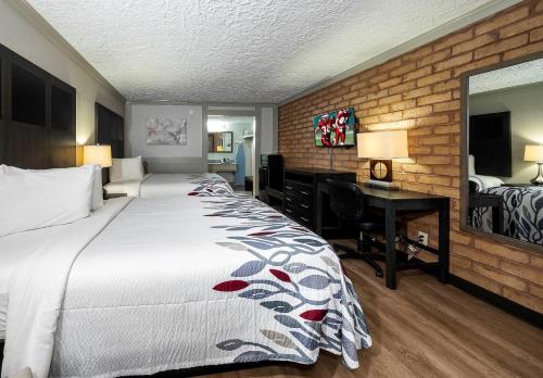 - une chambre d'hôtel avec un lit et un bureau dans l'établissement Red Roof Inn Monroe, à Monroe