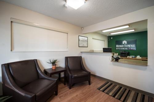 a waiting room at a phone clinic with two chairs at HomeTowne Studios by Red Roof Seattle - Kent/Des Moines in Des Moines