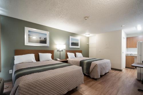 una habitación de hotel con 2 camas en una habitación en HomeTowne Studios by Red Roof Seattle - Kent/Des Moines, en Des Moines