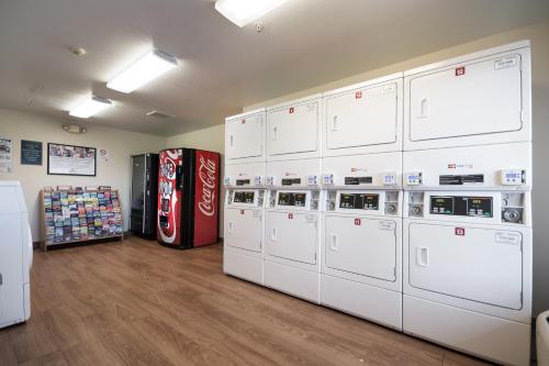 a row of machines in a room with a soda machine at HomeTowne Studios by Red Roof Seattle - Kent/Des Moines in Des Moines