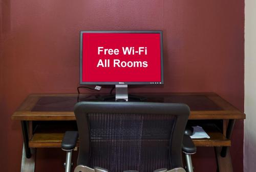 a computer monitor sitting on top of a desk with a chair at Red Roof Inn Lancaster in Lancaster