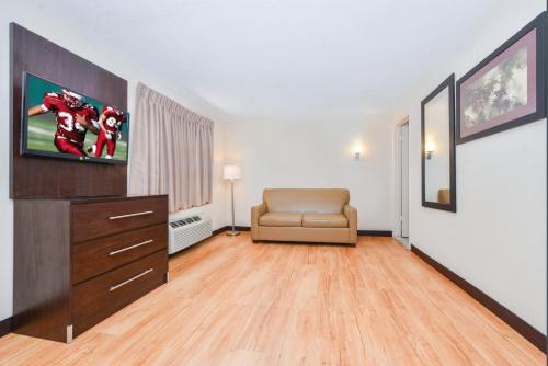 a living room with a couch and a dresser at Red Roof Inn PLUS+ & Suites Guilford in Guilford