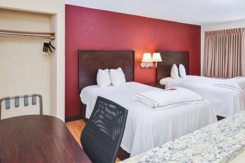 A bed or beds in a room at Red Roof Inn PLUS+ & Suites Guilford