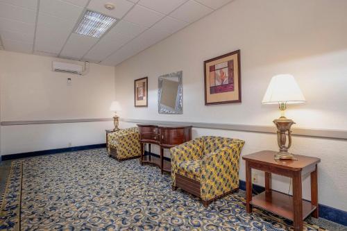 a waiting room with chairs and a table and lamps at Red Roof Inn & Suites Macon in Macon