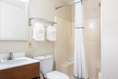 a bathroom with a toilet and a sink and a shower at HomeTowne Studios by Red Roof Rancho Cordova in Rancho Cordova