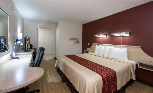 a hotel room with a large bed and a table at Red Roof Inn Hagerstown - Williamsport, MD in Williamsport