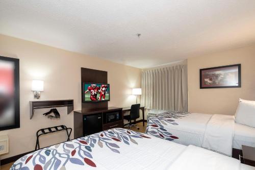a hotel room with a bed and a tv at Red Roof Inn Raleigh Southwest - Cary in Cary