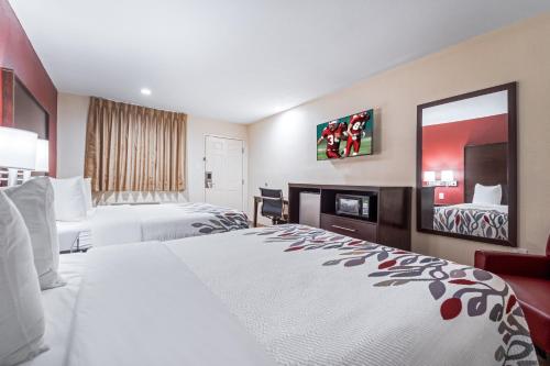 a hotel room with two beds and a mirror at Red Roof Inn Houston – Spring North in Spring
