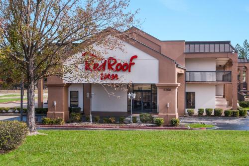 a restaurant with a red sign on the side of a building at Red Roof Inn Texarkana in Texarkana