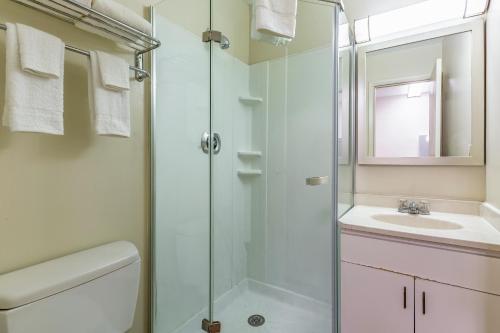 a bathroom with a shower and a toilet and a sink at HomeTowne Studios by Red Roof Atlanta NE – Norcross South in Norcross