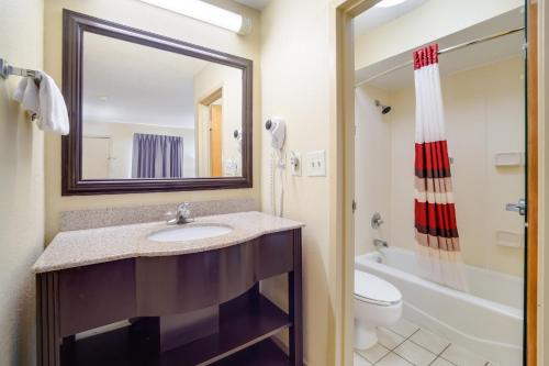 ein Badezimmer mit einem Waschbecken, einem WC und einem Spiegel in der Unterkunft Red Roof Inn Augusta – Washington Road in Augusta