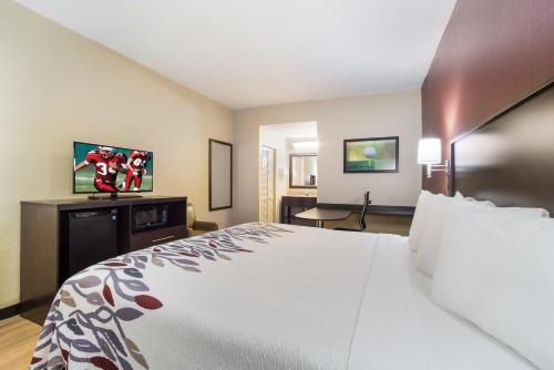 a hotel room with a large bed and a desk at Red Roof Inn Augusta – Washington Road in Augusta