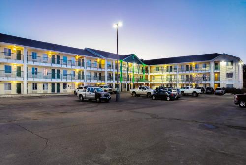 a large building with cars parked in a parking lot at HomeTowne Studios by Red Roof Colorado Springs - Airport in Colorado Springs