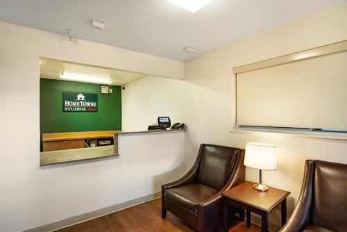a meeting room with two chairs and a projection screen at HomeTowne Studios by Red Roof Colorado Springs - Airport in Colorado Springs