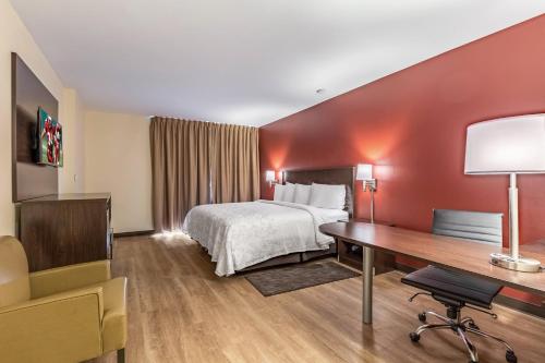 a hotel room with a bed and a desk at Red Roof Inn PLUS & Suites Houston - IAH Airport SW in Houston