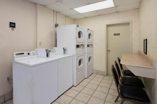 a laundry room with white appliances and a table and chairs at Red Roof Inn Myrtle Beach Hotel - Market Commons in Myrtle Beach