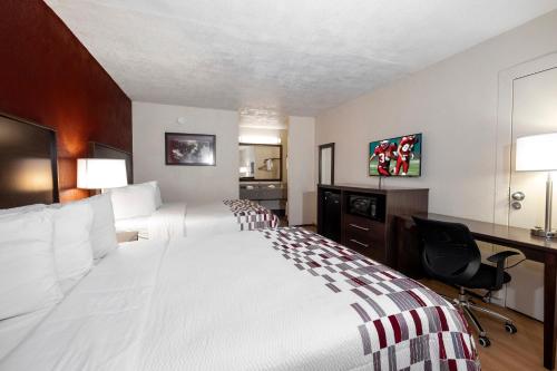Una habitación de hotel con una cama grande y un escritorio. en Red Roof Inn West Point, en West Point