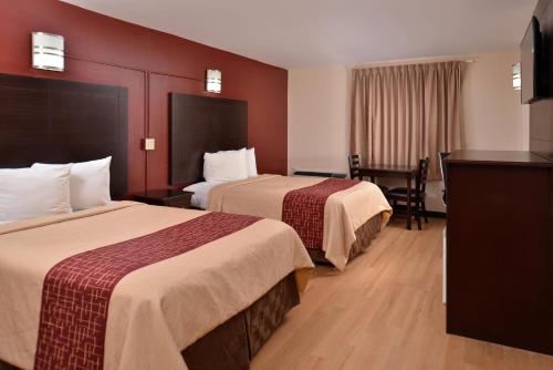 2 camas en una habitación de hotel con paredes rojas en Red Roof Inn Van Horn, en Van Horn