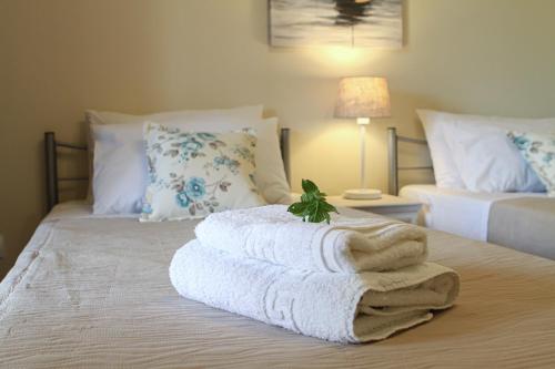a bed with a pile of towels on it at Navigator Villas - Houses in Acharavi