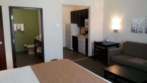 a room with a bed and a living room at PetroStay Inn & Suites Cotulla in Cotulla