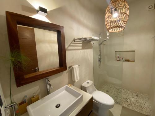 a bathroom with a sink and a toilet and a mirror at Kaanal Tulum in Tulum