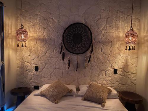 a bedroom with two lights and a bed with two pillows at Kaanal Tulum in Tulum