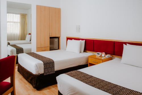 a hotel room with two beds and a television at WinMeier Hotel y Casino in Chiclayo