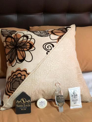 a pillow with a flower pattern on a bed at Hotel Casa Santa Lucía in Baños
