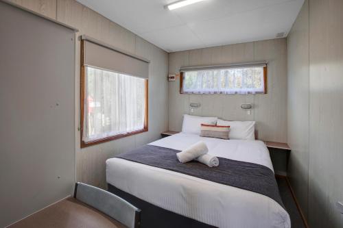 a small bedroom with a bed and a chair at BIG4 Taggerty Holiday Park in Taggerty