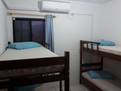 two bunk beds in a room with a window at Casa na praia 02 in Itapema