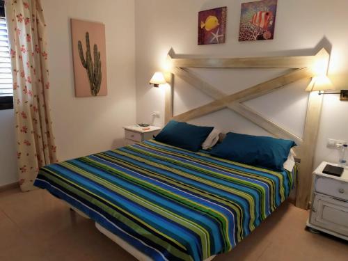 コラレホにあるAppartamento privato Oasis Tamarindoのベッドルーム1室(大型ベッド1台、木製ヘッドボード付)